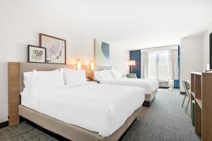 a hotel room with two beds and a television at Inn at Philadelphia Airport in Philadelphia