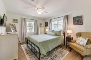 une chambre avec un lit, une chaise et des fenêtres dans l'établissement Walk to Dtwn Pine Mountain! Evergreen Cottage, à Pine Mountain