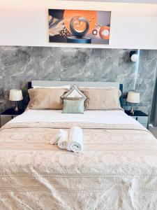 a bedroom with a large white bed with two lamps at Crystal Luxury Studio At Kass 1000 in Accra +26 photos