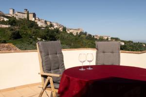 a table with two wine glasses on top of a balcony at Terrazza Mira - Vista panoramica e parcheggio a Todi in Todi