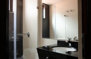 a bathroom with a sink and a mirror and a shower at The Cranky Croc Hostel in Bogotá