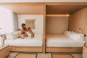 a child playing with a teddy bear on two beds at Crowne Plaza Merida by IHG in Mérida +156 photos