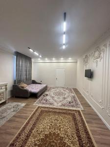 a room with a bed and a couch and a rug at House Halal Hotel in Almaty