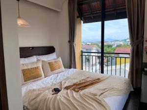 a bedroom with a bed with a view of a balcony at Hue Memories Signature in Thôn Trường Giang +119 photos