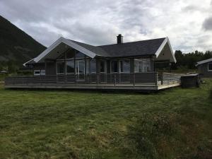 een groot huis met een grote veranda op een veld bij Tromsø idyllic cabin in Tromsø