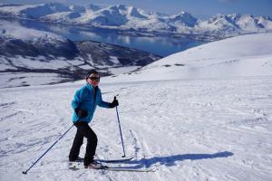 a woman on skis in the snow on a mountain at Tromsø idyllic cabin in Tromsø