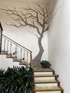 a mural of a tree on the wall of a staircase at The Cranky Croc Hostel in Bogotá