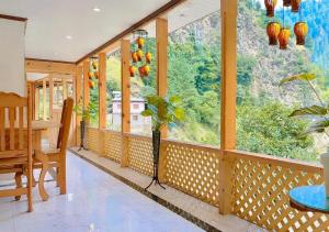 a dining room with a table and a large window at The Royal Peaks in Kundālshai