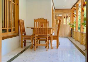 a dining room with a wooden table and chairs at The Royal Peaks in Kundālshai