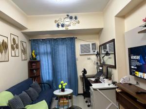 a living room with a blue couch and a desk at Bayfront Suite in Pasay, Manila Near NAIA Terminal, PICC, Star City, MOA and US Embassy - Pet-Friendly, Free Pool, Wi-Fi & Netflix in Manila
