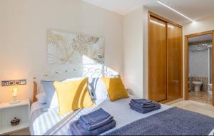Schlafzimmer mit einem Bett mit blauen und gelben Kissen in der Unterkunft Soleado Albir in Albir + 62 Fotos