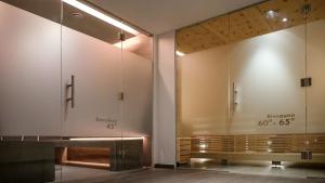 a bathroom with a large mirror and a bench at Black Summit Samnaun Boutique Hotel in Samnaun +72 photos