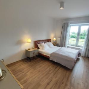 a bedroom with a bed and a large window at Apartament Stara Elektownia z garażem in Zamość