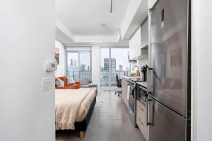 1 dormitorio con 1 cama y cocina con ventanas en Stylish Cozy Studio Condo Downtown, en Toronto