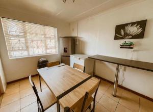 a kitchen with a table and a table and chairs at 4 Jooste Street in Windsor Park