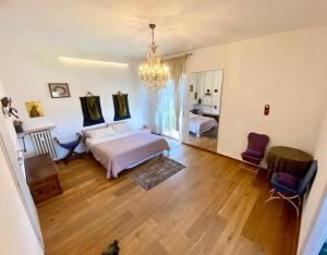 a bedroom with a bed and a chandelier at L'Ultimo Piano b&b Forlì in Forlì