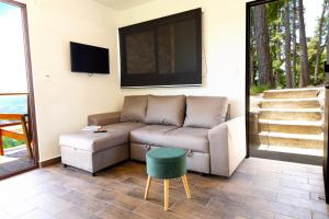 a living room with a couch and a tv at VIU Boutique Cabins in San Salvador