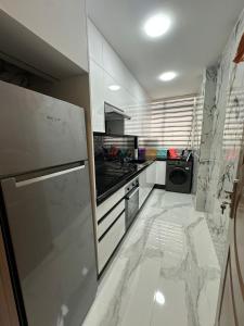 a kitchen with white marble floors and a refrigerator at pacotanjawi al manzil in Tangier