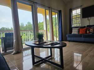 a living room with a coffee table and a balcony at Royal Escape - 2 in Anse La Raye