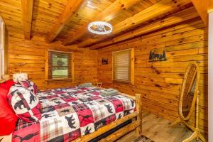 una camera con un letto in una baita di tronchi di Luxury Spacious Cabin Hot Tub, Theater, 5 Acres in Hocking Hills a Logan