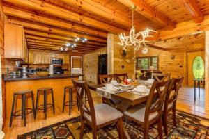 una cucina e una sala da pranzo con tavolo e sedie di Luxury Spacious Cabin Hot Tub, Theater, 5 Acres in Hocking Hills a Logan