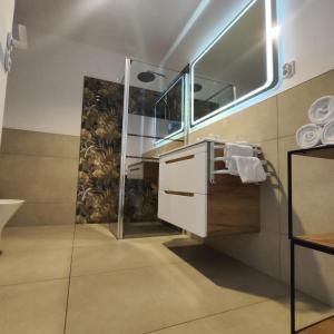 a bathroom with a shower and a sink and a mirror at Apartament Stara Elektownia z garażem in Zamość +15 photos