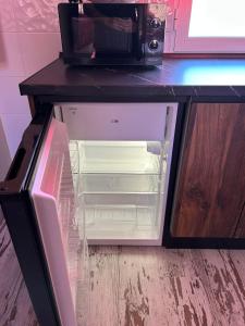 a refrigerator with its door open and a microwave at El RINCONCITO in Mahora +7 photos