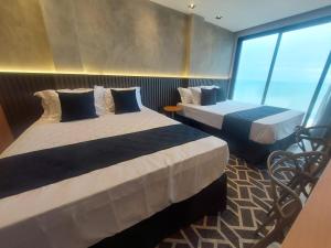 マカエにあるV-Home Flat Hotelのベッドが2つと窓があるホテルの部屋