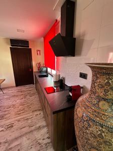 una cucina con bancone e parete rossa di El RINCONCITO a Mahora