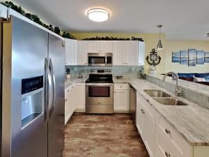 a kitchen with white cabinets and stainless steel appliances at Put-in-Bay Waterfront Condo #113 in Put-in-Bay