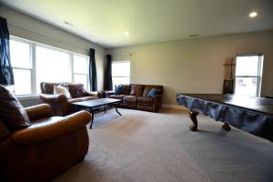 a living room with couches and a ping pong table at Comfortable and Modern Cabin Rental on Lake Red Rock near Pella, Iowa in Pella +18 photos