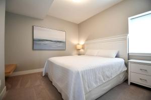 a bedroom with a white bed and a picture on the wall at Comfortable and Modern Cabin Rental on Lake Red Rock near Pella, Iowa in Pella