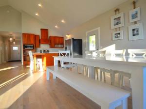a kitchen and dining room with a white table and chairs at Comfortable and Modern Cabin Rental on Lake Red Rock near Pella, Iowa in Pella