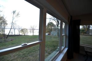 a window in a house with a view of a field at Comfortable and Modern Cabin Rental on Lake Red Rock near Pella, Iowa in Pella