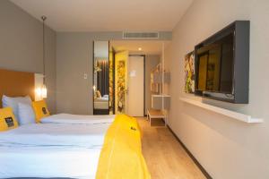 a hotel room with a bed and a flat screen tv at Holiday Inn - the niu, Dairy Haarlem in Haarlem