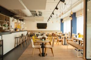 a restaurant with tables and chairs and a bar at Holiday Inn - the niu, Dairy Haarlem in Haarlem