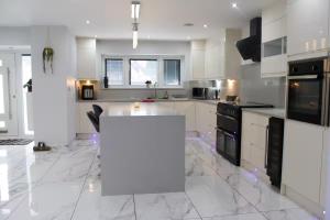 Una cocina con gabinetes blancos y una encimera blanca. en Falcon house 7 bedrooms, en Hawley