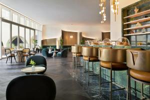 a lobby with a bar with chairs and tables at Kimpton KAFD Riyadh by IHG in Riyadh