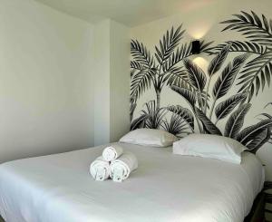 Un dormitorio con una cama con toallas. en Appartement Parking Metro, en Caluire-et-Cuire