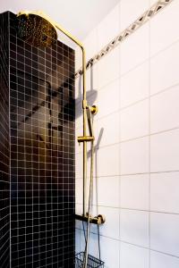 een douche in een badkamer met zwart-witte tegels bij Just steps behind the Royal Palace in Oslo
