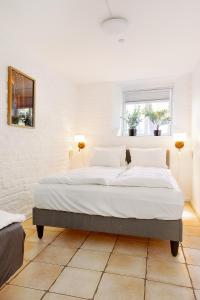 een slaapkamer met een groot bed met witte lakens bij Just steps behind the Royal Palace in Oslo