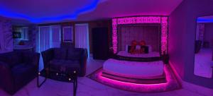 a living room with pink lighting and a table and chairs at Mansa Apartments in Bradford