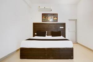 een slaapkamer met een groot bed met een houten hoofdeinde bij Hotel O Royal in Rewāri