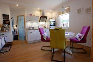 a kitchen with a table and two chairs and a table at Upland-Flair Ferienwohnung BLUMENWIESE im Zentrum! in Willingen