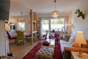 a living room with a couch and a table at Upland-Flair Ferienwohnung BLUMENWIESE im Zentrum! in Willingen