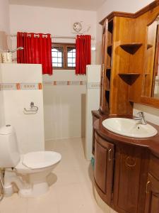 a bathroom with a toilet and a sink at Mansion Du Lac in Kottayam
