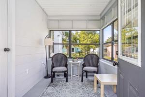 2 chaises et une table dans une chambre avec fenêtres dans l'établissement 6 Mi to Downtown Orlando Quiet Home with Sunroom, à Orlando
