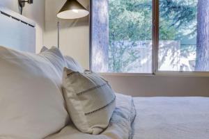 a bed with white pillows in a bedroom with a window at South Lake Chalet Boutique Suites - walk to Heavenly & Lake Tahoe in South Lake Tahoe