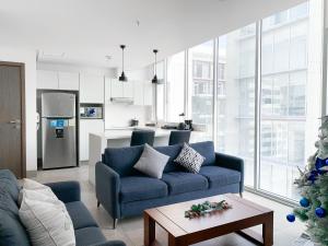 a living room with a blue couch and a kitchen at Luxury Suites frente mall del sol a pocos minutos del aeropuerto y terminal terrestre in Guayaquil
