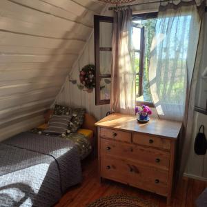 Un dormitorio con una cama y una cómoda y una ventana. en Wieża marzeń, en Dąbrowa Grodzieńska-Wieś
